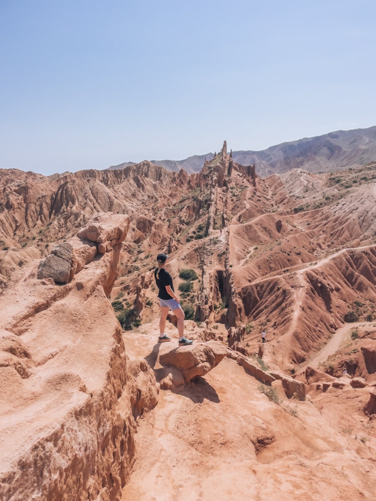 A girl standing and admiring the stunning rock formations in Fairy Tale Canyon in Kyrgyzstan